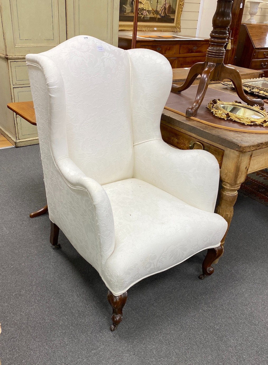 A Victorian upholstered wing armchair, on front cabriole legs, width 70cm, depth 75cm, height 114cm